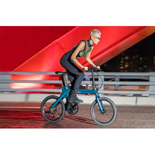 Rider commuting on a cyan blue Fiido X folding electric bike